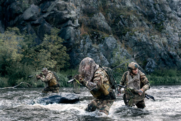 istock Three mercenary soldiers ford a river during a special operation. 1417598969
