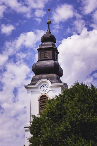 istock Tall clock tower from the trees against the blue sky 1417601527