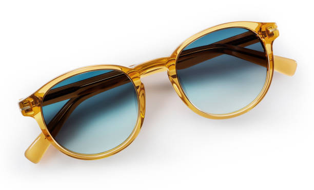 透明なプラスチックの金色の明るい色のサングラス。アイウェアの上面図と影付き。白い背景に隔離されたトレンディなメガネ。青い色合いの偏光レンズを持つ女性のためのファッション眼�