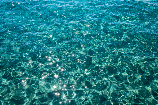 Rippled gleaming aquamarine sea water surface with shiny sparkles