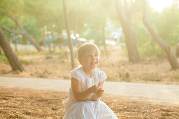 Happy adorable little girl outdoors in summer, lighting effect