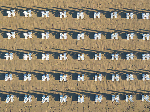 Sunbeds and umbrellas lined up on the beach at sunrise