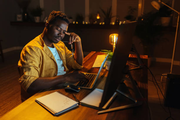 istock Bored african man working on laptop at home 1417612264