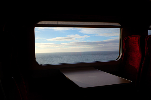 The view from a train window. Exploring Scotland by train, with a sea view. The weather is cloudy and the light is soft. It is very quiet and peaceful.