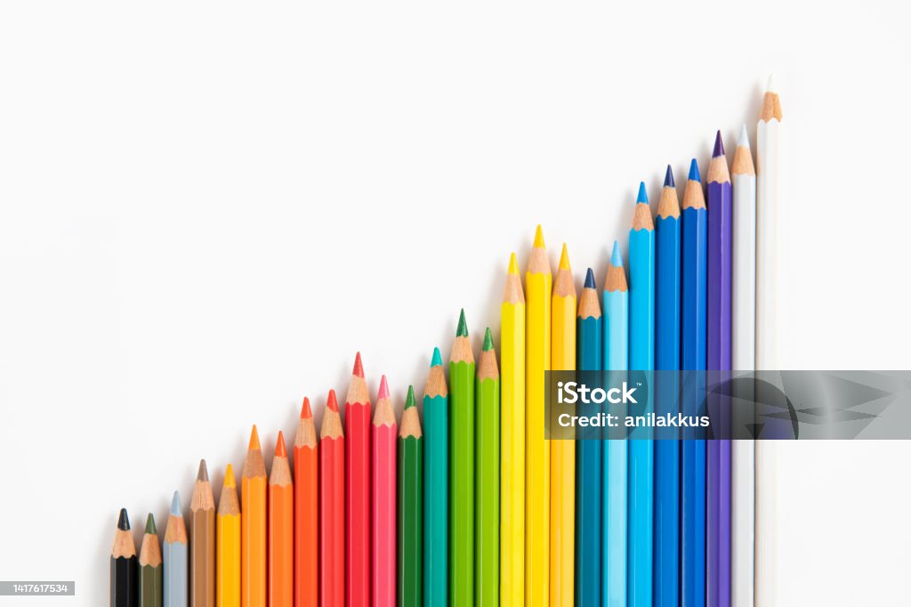 Colored Pencils in a Row on White Background Close-up of colored pencils in a row on white background with copy space Colored Pencil Stock Photo