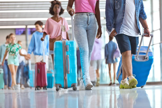 istock Passengers with wheeled luggage at airport 1417619244
