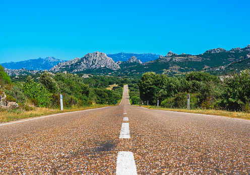 Asphalt road and white stripe. The strip on the asphalt is directed forward. Provincial road near Aggius, Sardinia - Italy