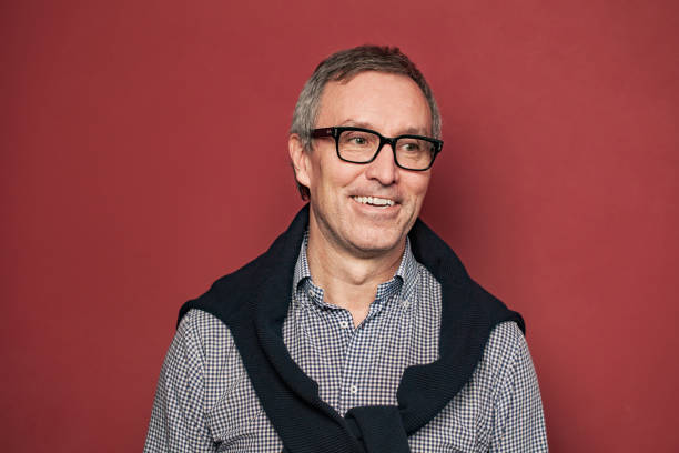 Happy professional mature man on red background portrait