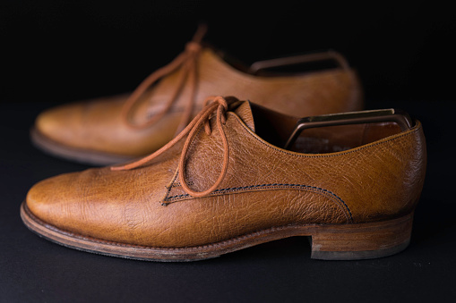 Brown men's shoes on split background.
