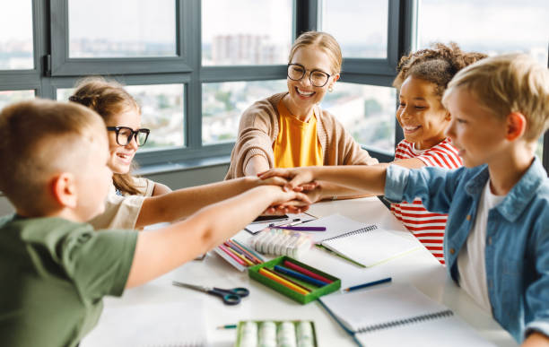 istock Teacher and joyful students celebrate   successful completion of collective school work in a bright classroom 1417626823