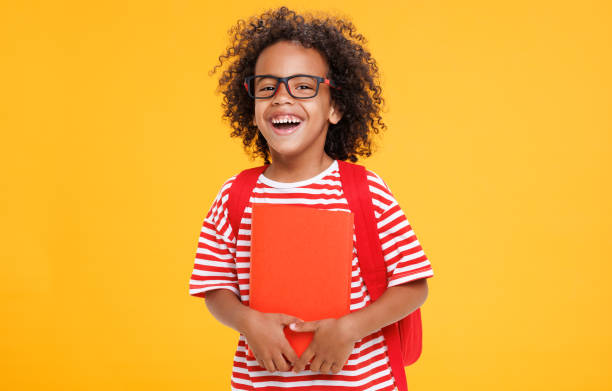 istock Happy ethnic schoolboy laughing with book 1417627299
