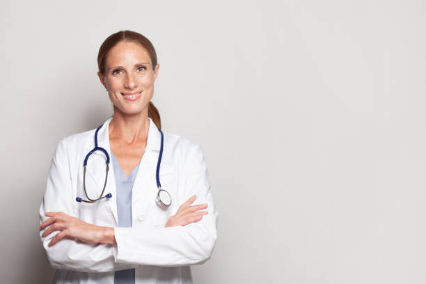 istock Friendly woman doctor in white uniform smiling looking at camera 1417627556