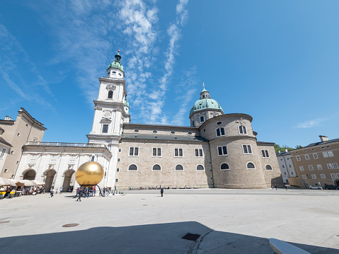 The view over Salzburg, Austria on a bright spring evening.  In the foreground is the Domplatz square beside the Cathedral. In the background is the Hohensalzburg fortress.