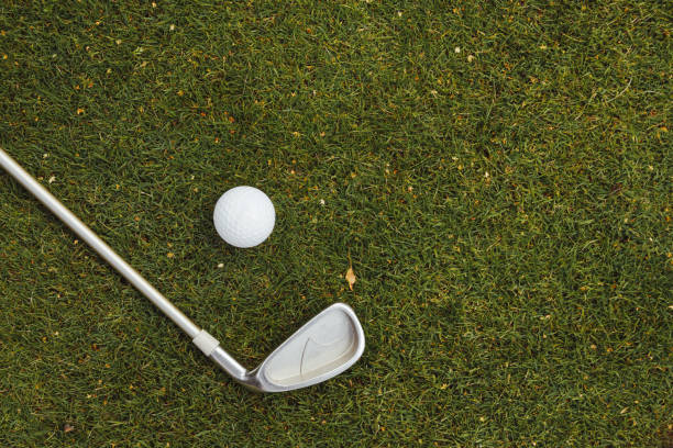 istock Golf ball and golf club on green grass on golf course, flat lay, top view 1417630865