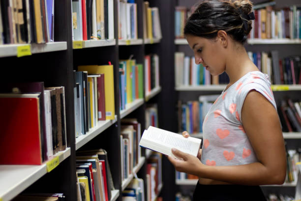 istock Beautiful female girl taking a book  in a university library 1417634603
