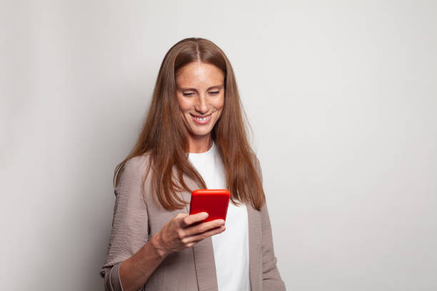 istock Cheerful friendly woman messaging, browsing internet, using smartphone and shopping on white background 1417635869