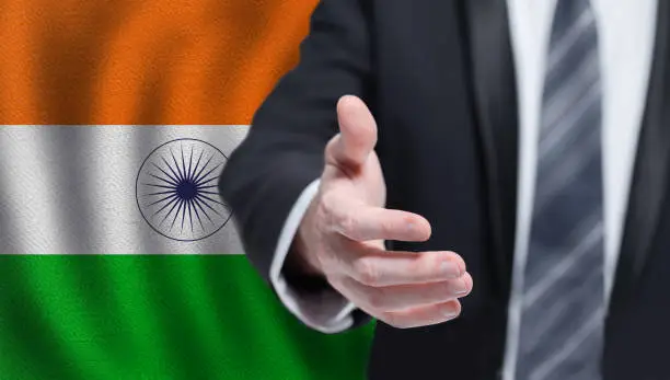 Photo of Indian business, politics, cooperation and travel concept. Hand on flag of Iindia background.