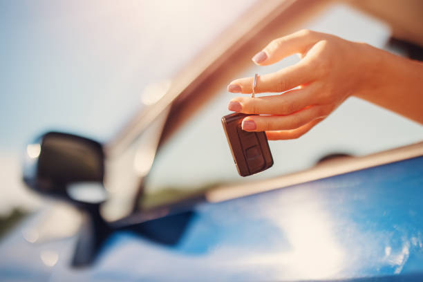 Woman's hand holding key from her new car