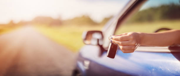 Woman's hand holding key from her new car stock photo