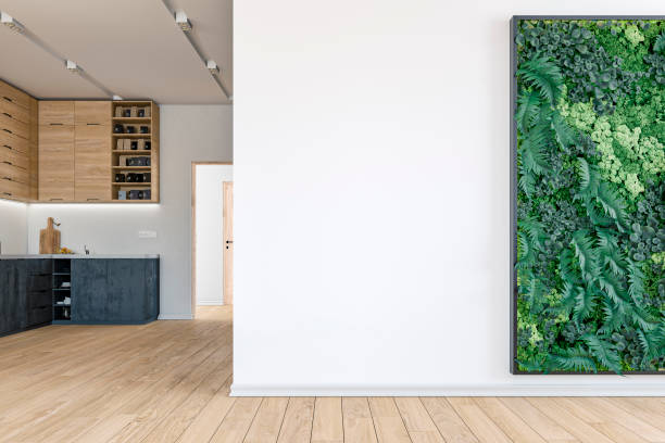 istock Empty living room with a large plaster wall, vertical garden and a modern kitchen  in the background 1417641362