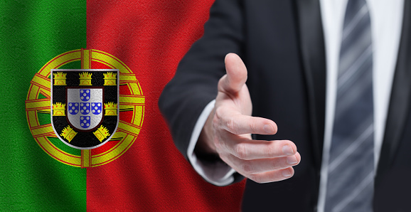 Portuguese business, politics, cooperation and travel concept. Hand on flag of Portugal background.