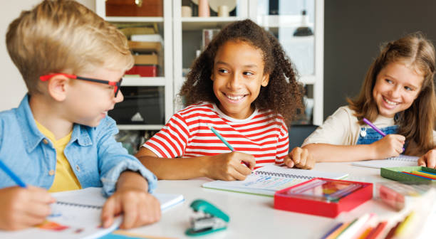 istock Cheerful ethnic girl solving test with classmates 1417643116