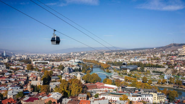 funivia sopra tbilisi con vista mtkvari, fiume kura e ponte della pace, georgia - kura river immagine foto e immagini stock