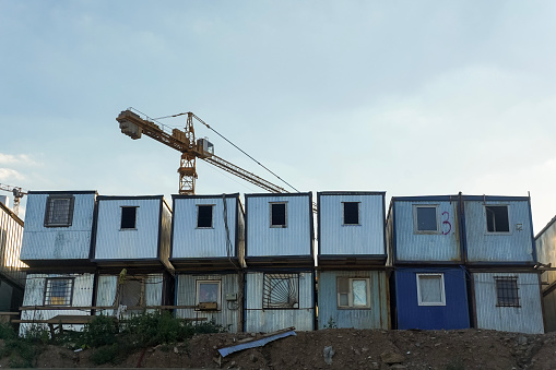 Metal cabins for workers and a crane on the building site