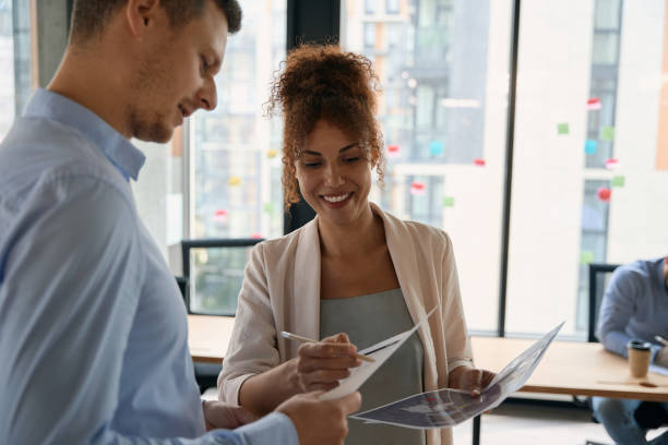istock Happy man and woman discussing documents in hands office 1417648692