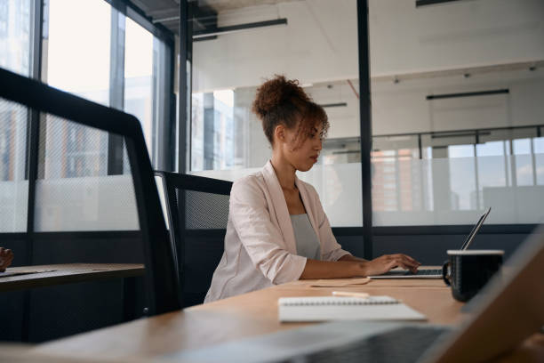 istock Focused woman working on laptop in loft style coworking space 1417649037