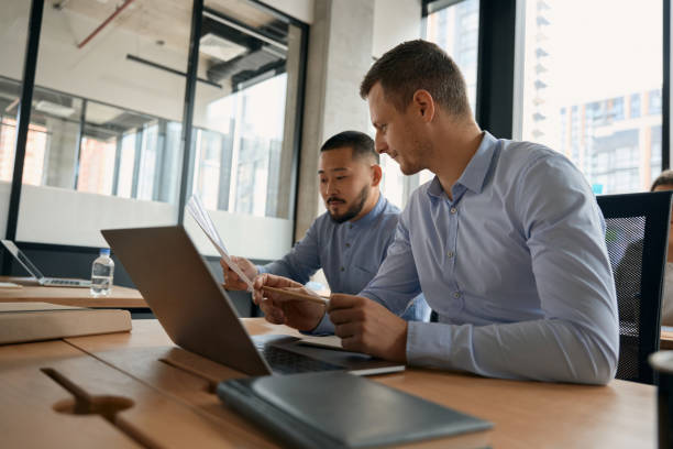 istock Two men are discussing documents in hands, being in office 1417649065