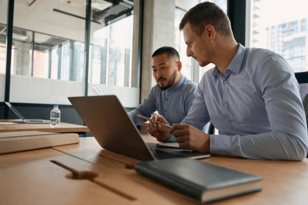 istock Attractive male colleagues discussing while being in office 1417649089