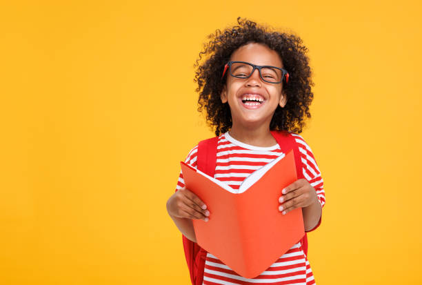 istock Happy ethnic schoolboy laughing with book 1417650203
