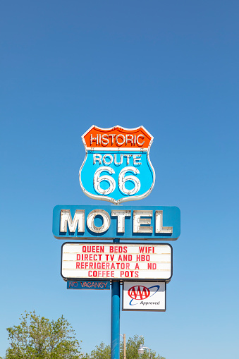 Seligman, USA - May 25, 2022: Motel and Route 66 sign  on Historic Route 66. Built in 1904. The neon light lost color but is still in use.