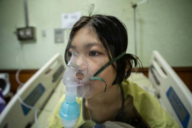 Close up sick Yong asian girl with face oxygen mask stock photo