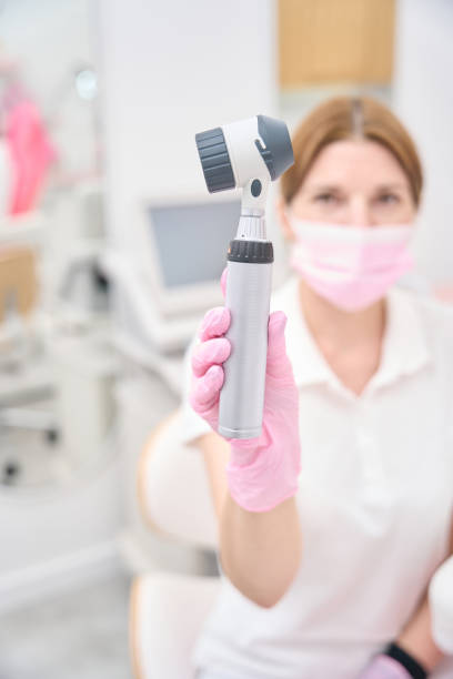istock Dermatologist showing diagnostic device for skin examination before camera 1417660275