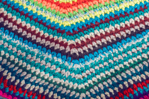Colorful knitted background from colored threads for knitting. The concept of knitting warm things, rugs