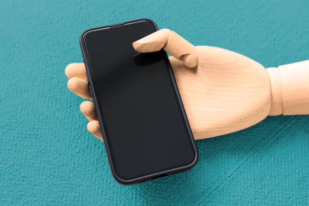 istock Modern mobile phone in a wooden hand on a turquoise background 1417662608