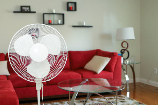 A standing revolving fan in a living room stock photo