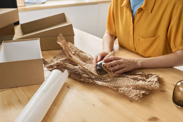 istock Woman packing bottles in boxes 1417664378