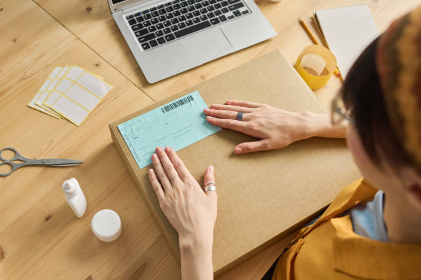 istock Woman sticking receipt on parcel 1417664492