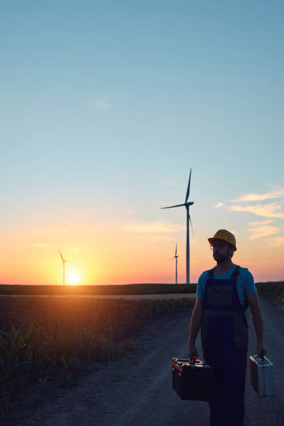 istock Engineer mechanic in a windmill farm park checking and servicing wind turbines. 1417664985