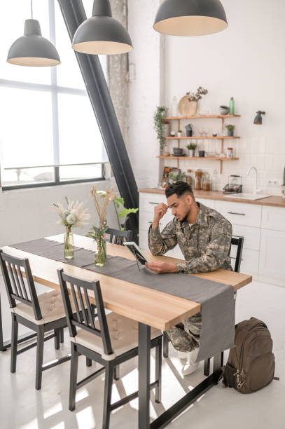 istock Sad young soldier staring at the photograph 1417666547