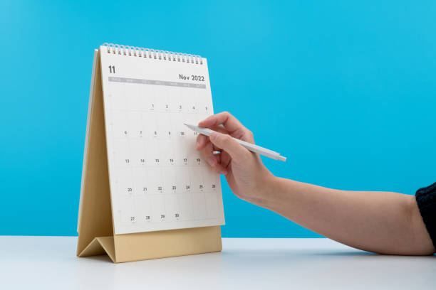 istock Woman hand with pen writing on calendar page 1417676039