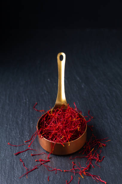 Food ingredient spice concept Saffron crocus spice in copper cup on black background with copy space Food ingredient spice concept Saffron crocus spice in copper cup on black background with copy space saffron stock pictures, royalty-free photos & images