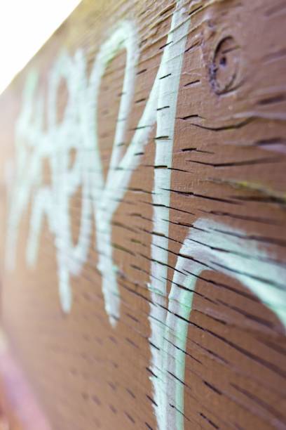 Close-up of paint graffiti on a wooden wall during the day