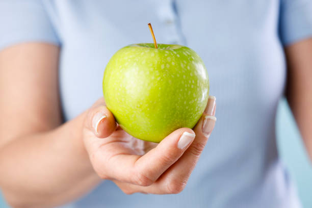 istock Woman holding green apple 1417679917
