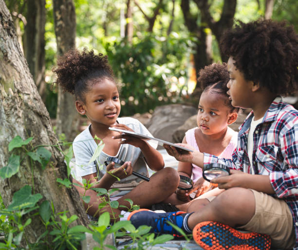istock Group African American kid explore with magnifying glass in the forest 1417680947
