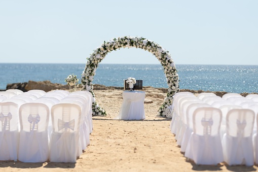 The wedding venue and a floral arch-shaped altar at the beach