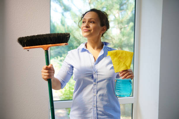 Beautiful Latin American housewife cutely smiles looking aside, holding broom, cloth and detergent while cleaning house. Beautiful Latin American young woman, a pretty housewife cutely smiles looking aside, holding a broom, cloth and detergent while enjoying spring general cleaning in the house. Housekeeping concept cutely stock pictures, royalty-free photos & images